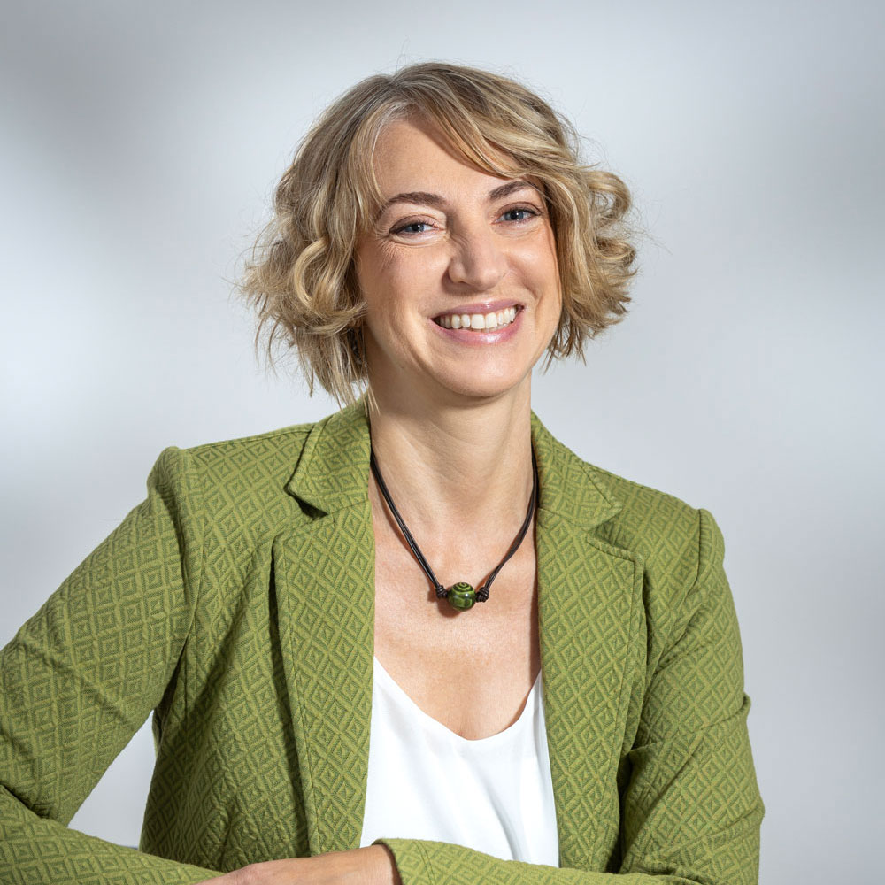 Cinzia, blond und im grünen Blazer, lächelt: Italienische Übersetzungen und Dolmetschdienste sind für sie kein Problem. (Kleines Bild)